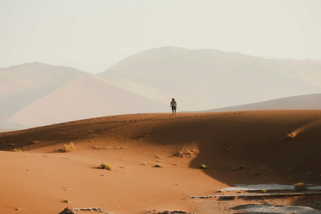 A man standing on a desert dune